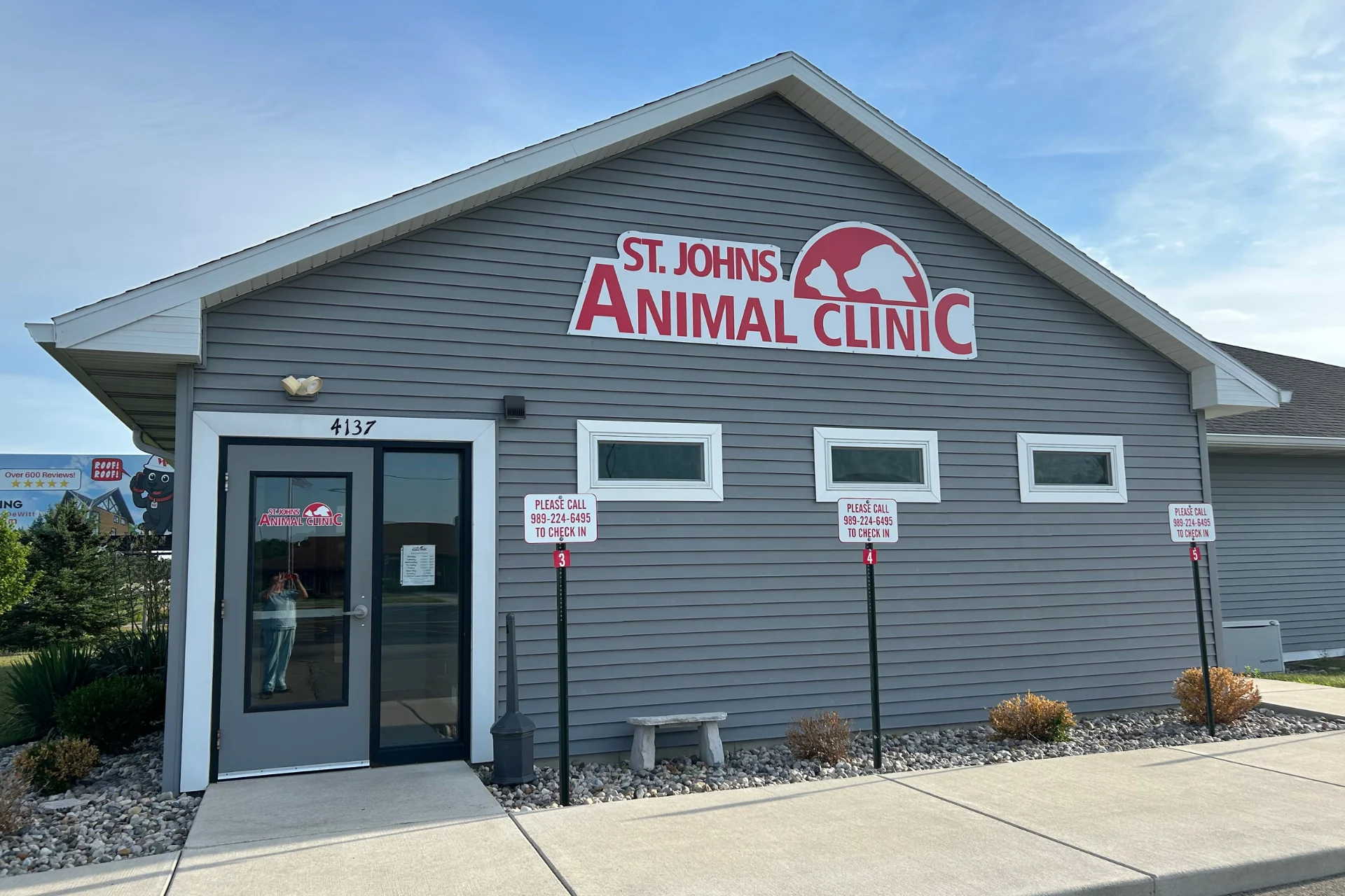 St. Johns Animal Clinic building Aerial view of a coastal city along a wide river or bay, with colorful buildings, a waterfront harbor, and green hills in the foreground under a cloudy sky.